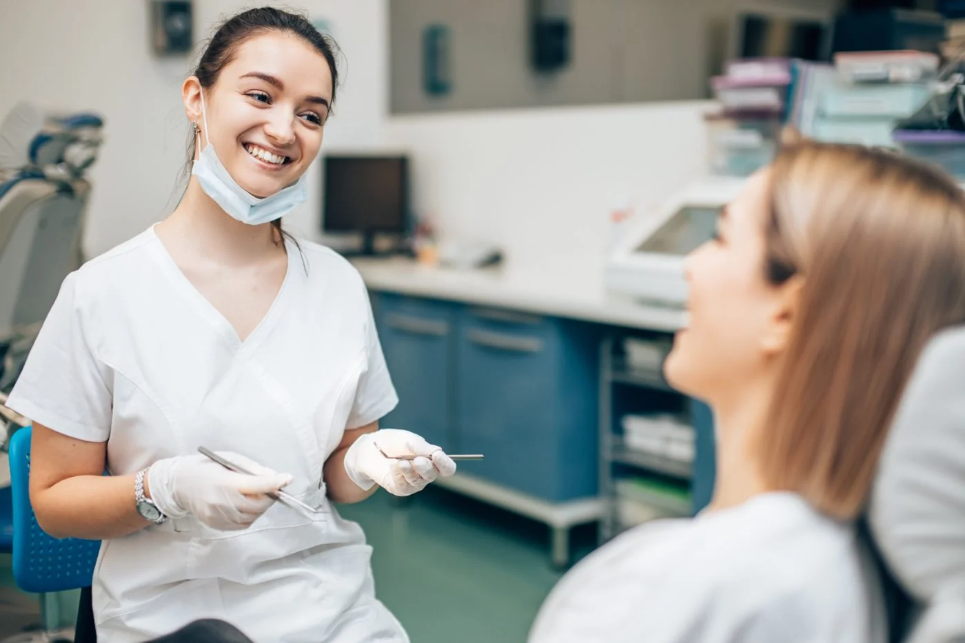 Dentalassistentin im Gespräch mit einer Patientin in einer Zahnarztpraxis